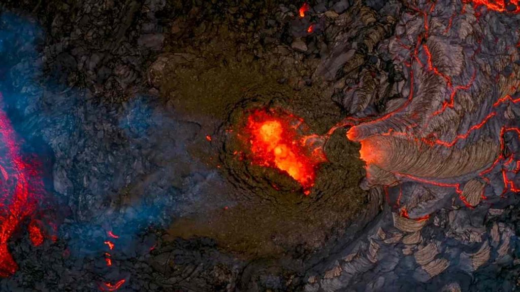 Ilustračná fotografia: Letecký pohľad na sopečnú erupciu na Islande, pri ktorej žeravá láva preteká cez tmavé bazaltové horniny. Sopečné horniny môžu obsahovať chemické stopy materiálu pochádzajúceho z hlbokého zemského plášťa. Nová vedecká štúdia naznačuje, že vodík starý miliardy rokov môže postupne prechádzať zo zemského jadra do plášťa. Foto: Pic2025 / Shutterstock